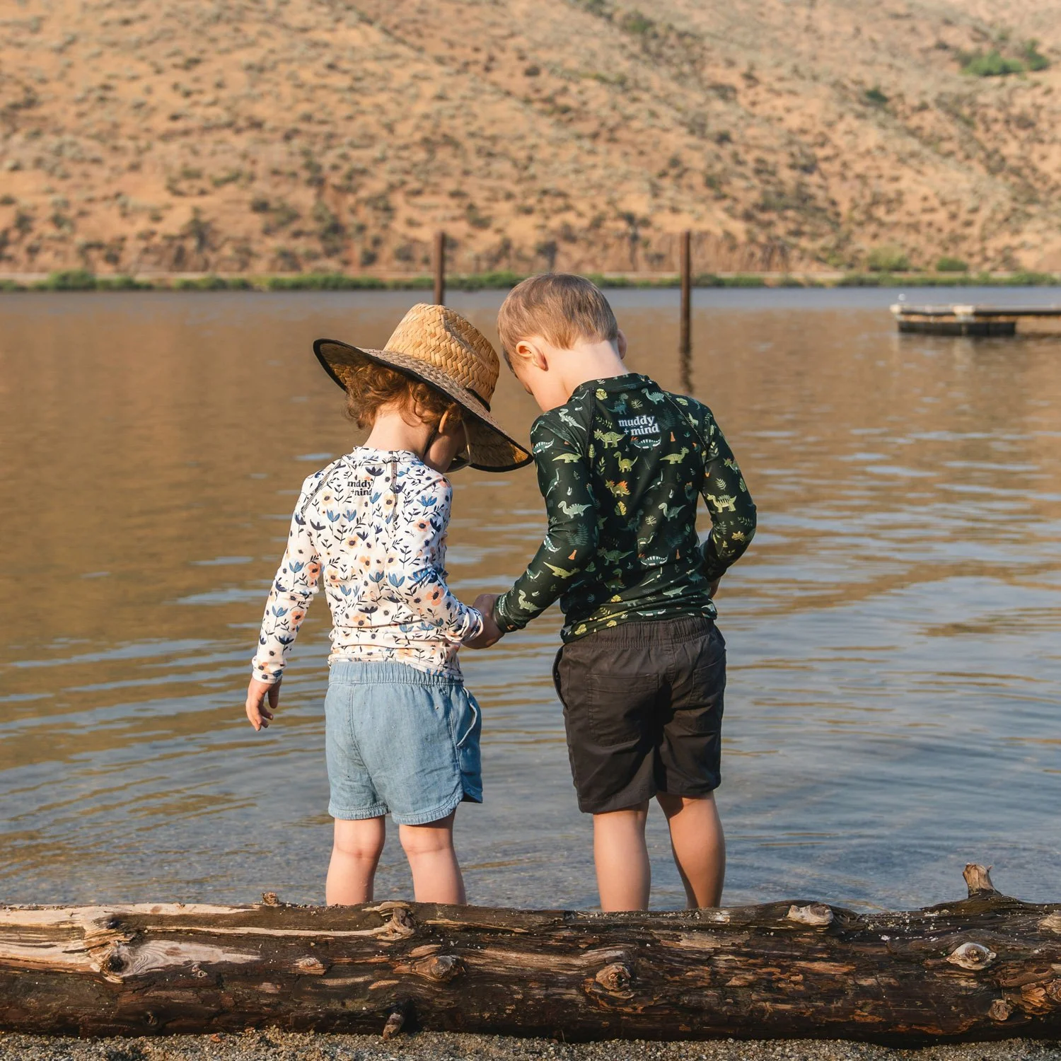 Two children play by a lake.