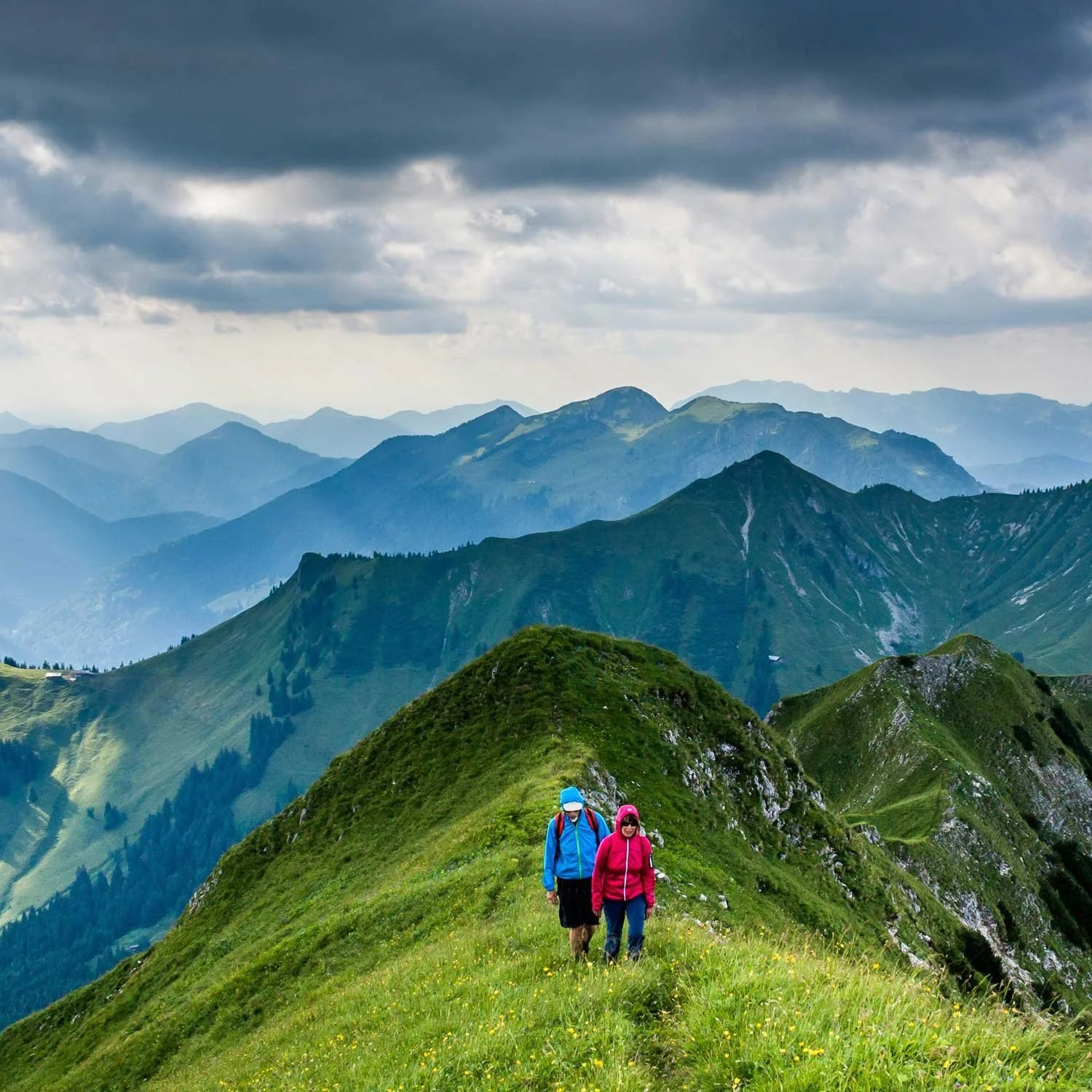 A couple hikes up a steep mountain side.