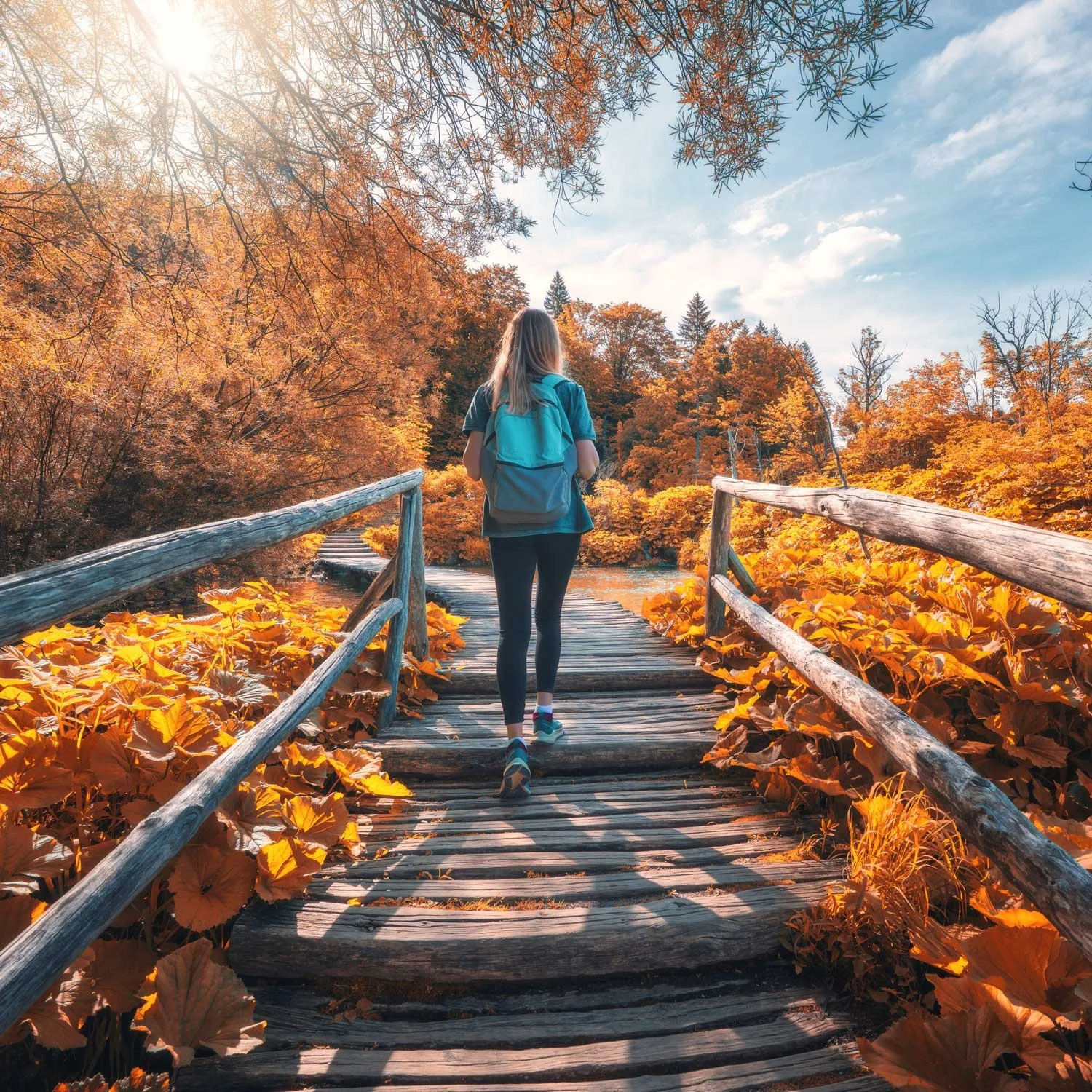 Woman hikes through a park in the fall.