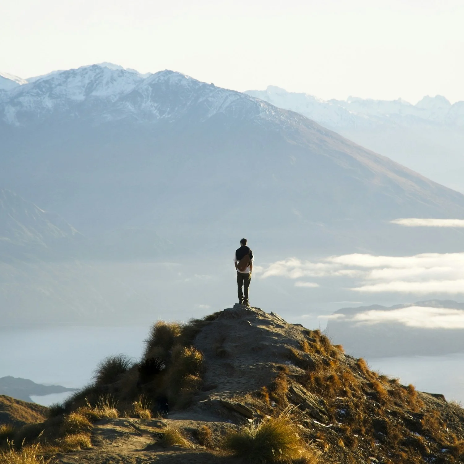 Solo hiker looks out on expansive view.