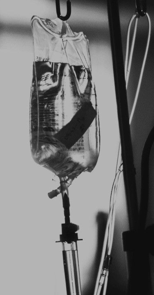 An IV drip bag hanging in a hospital setting.
