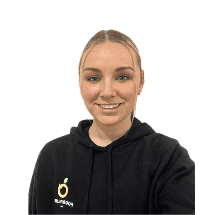 A young woman with blonde hair smiling, wearing a black hoodie with a logo and the text "FOODPLED" on it.