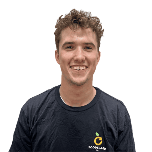 A young man with curly hair and a big smile wearing a black t-shirt with a Food Filled logo.