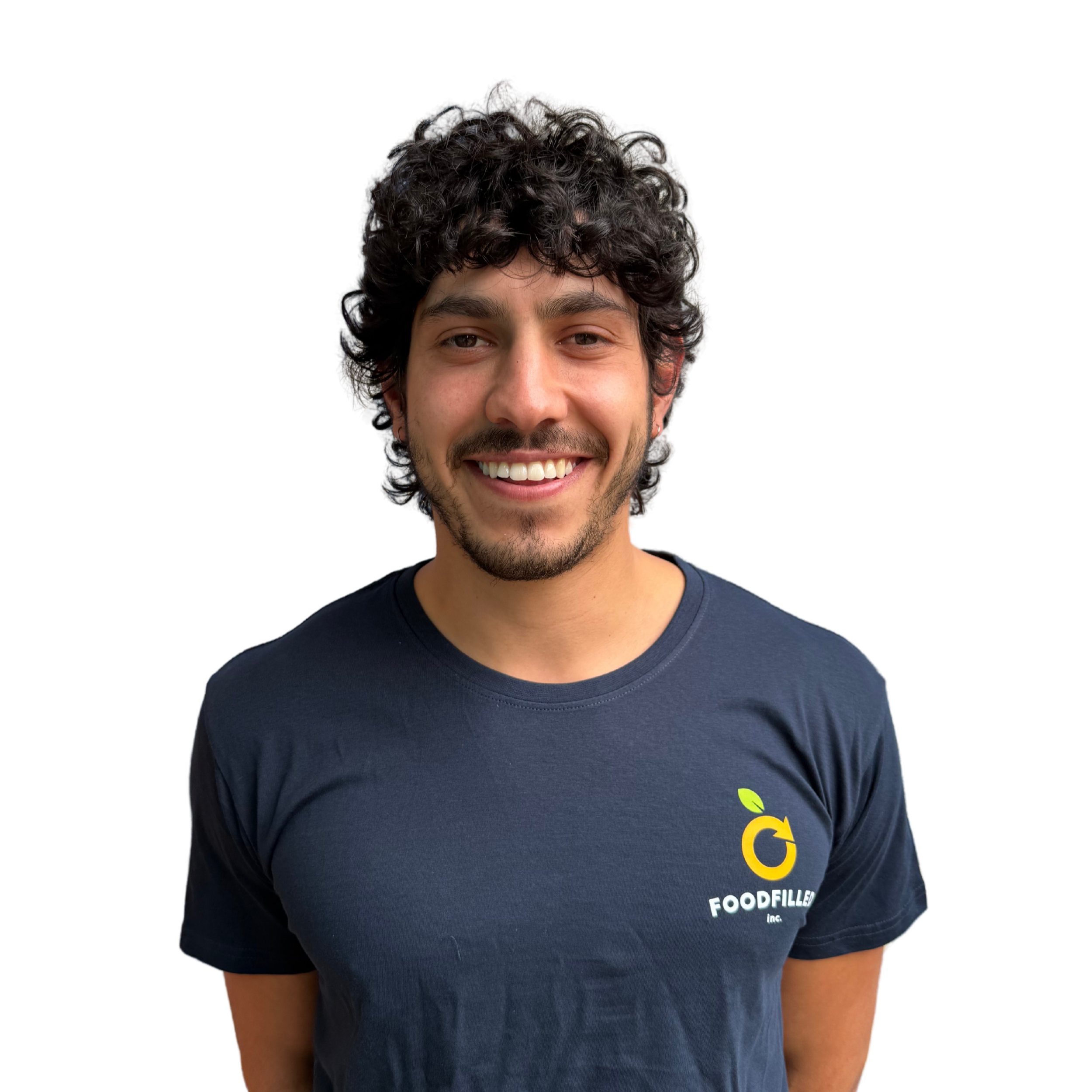 Kade with dark hair, facial hair, and wearing a black T-shirt with a logo that says 'FOODFILLED' and a small lime graphic.