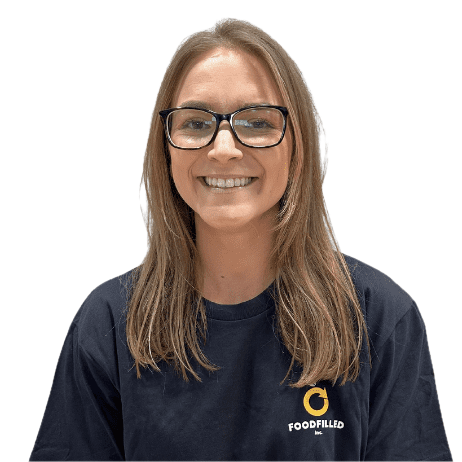Smiling woman with glasses, long brown hair, wearing a navy blue shirt with a logo that says Food Filled.