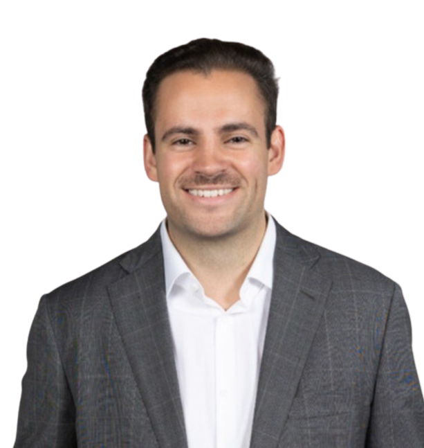 A smiling man in a white shirt and gray plaid suit against a black background.