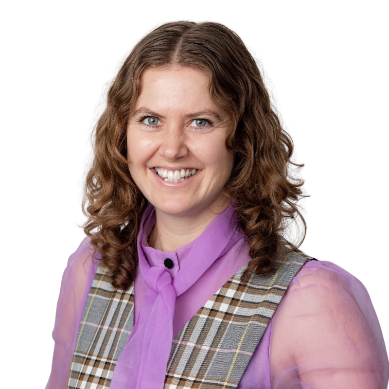 A woman with curly blonde hair smiling, wearing a navy blue t-shirt with a Food Filled logo on it.