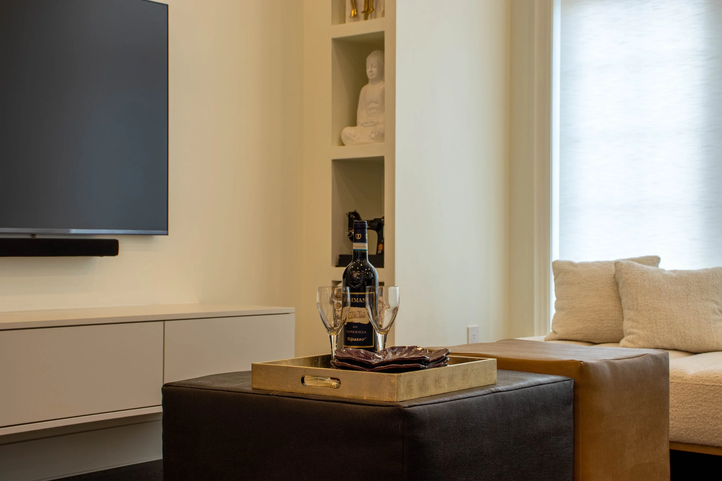 Luxury living room interior design in Toronto featuring custom media cabinetry, built-in shelving, and refined neutral furnishings