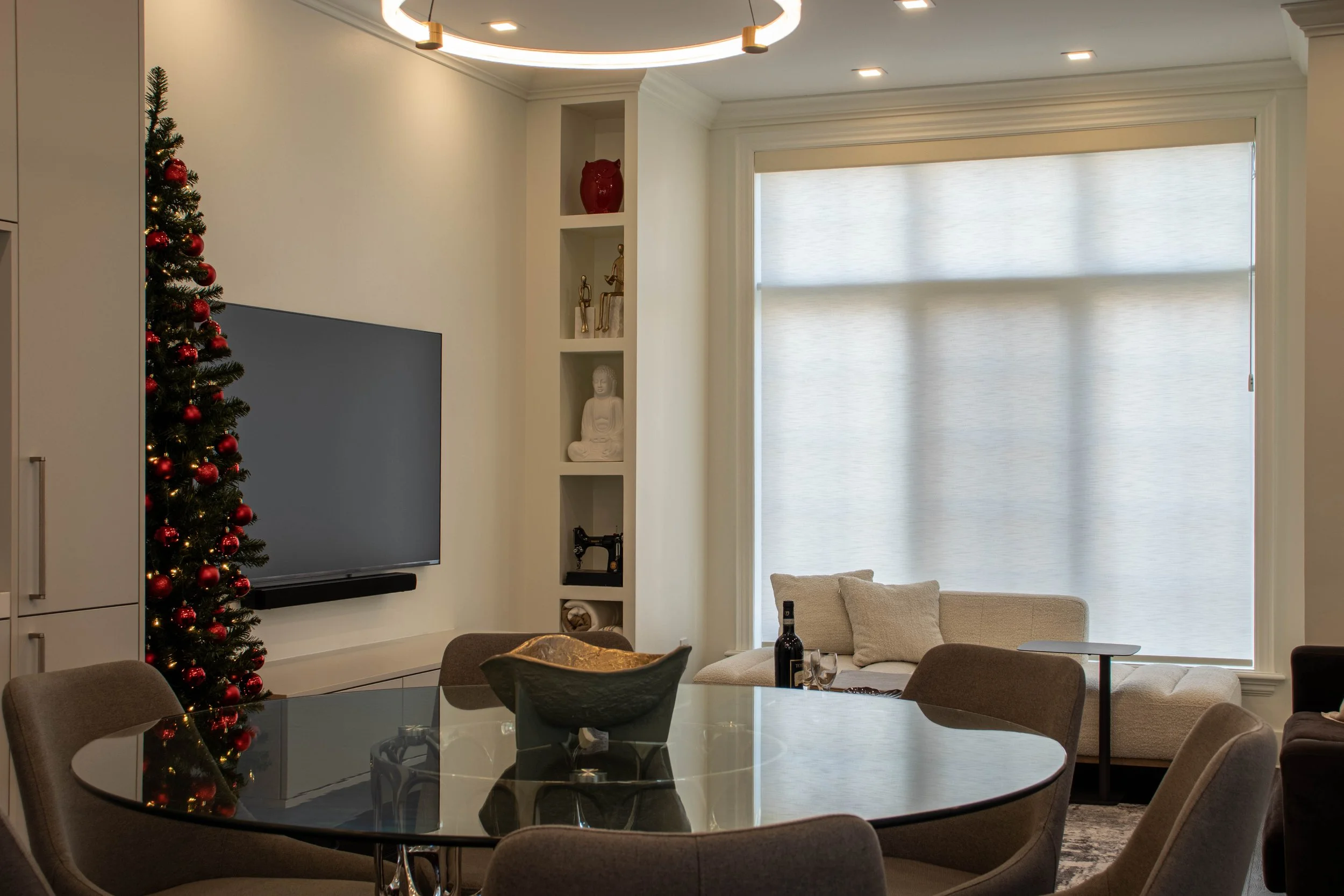 Luxury dining and living area interior design in Toronto with neutral furnishings, sculptural lighting, and custom built-in shelving