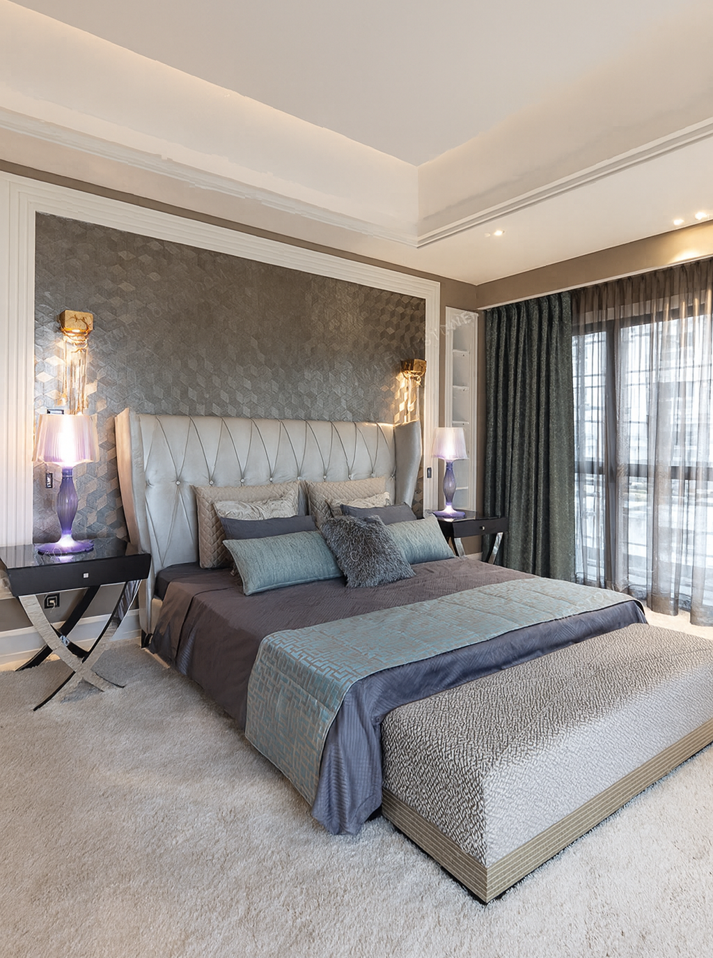 Elegant primary bedroom with a custom upholstered headboard, layered textures, and soft neutral tones designed for a family home.