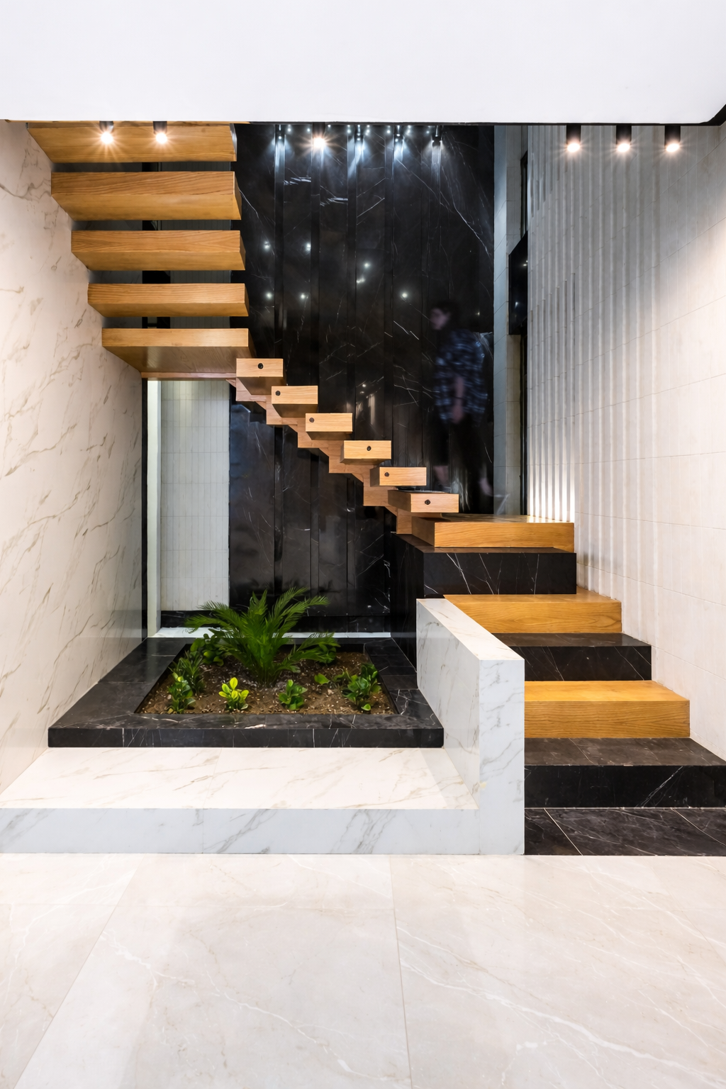 Luxury residential sculptural staircase with floating wood treads, integrated planter, and stone finishes designed by ReArt.