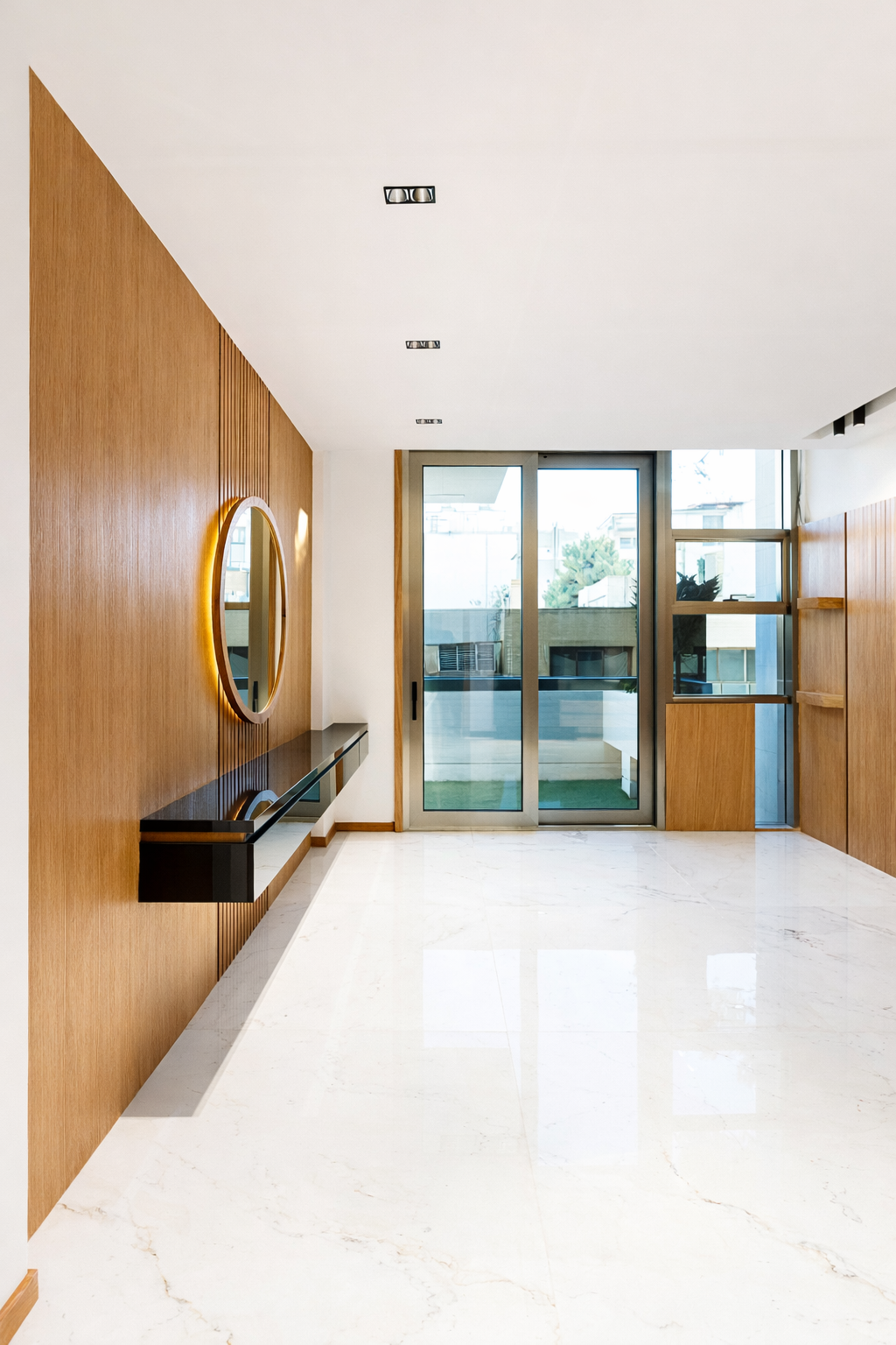 Luxury residential interior showcasing a marble feature wall, wood slat ceiling, and refined modern finishes designed by ReArt.