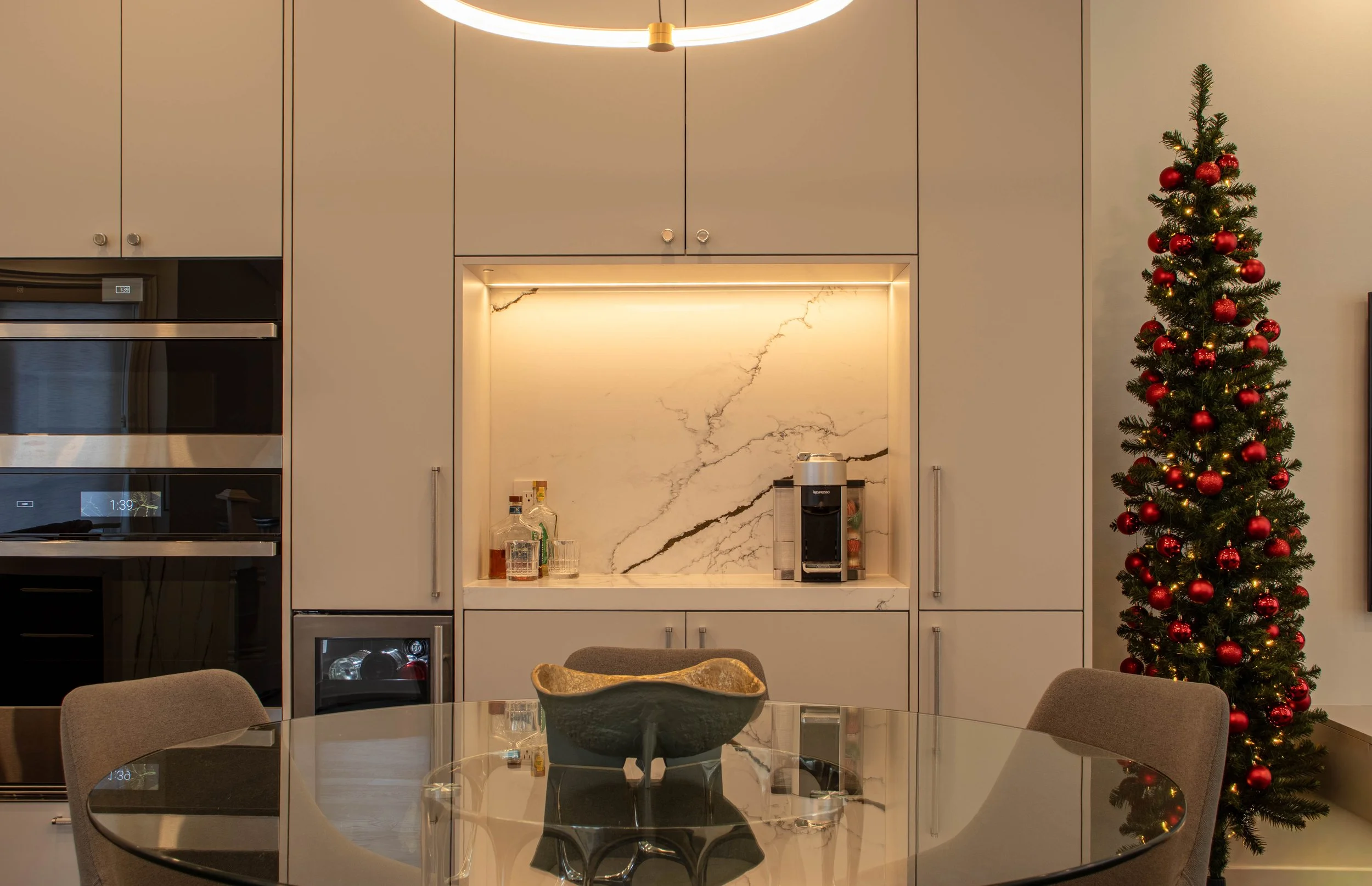 Luxury dining area interior design in Toronto featuring custom floor-to-ceiling cabinetry, integrated lighting, and marble back panel