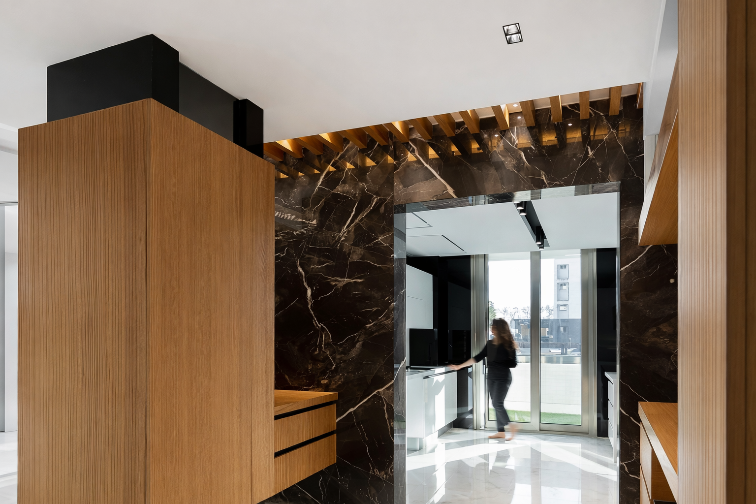 Modern residential kitchen passage featuring a marble feature wall, warm wood millwork, and architectural lighting designed by ReArt.