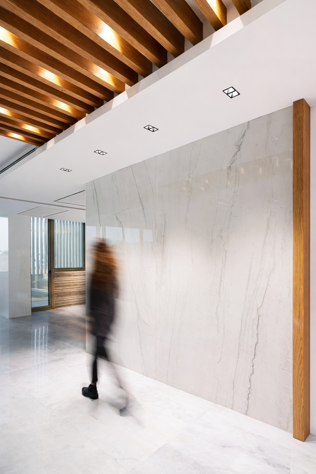 Modern residential hallway with wood slat ceiling, recessed lighting, and minimalist architectural detailing by ReArt.
