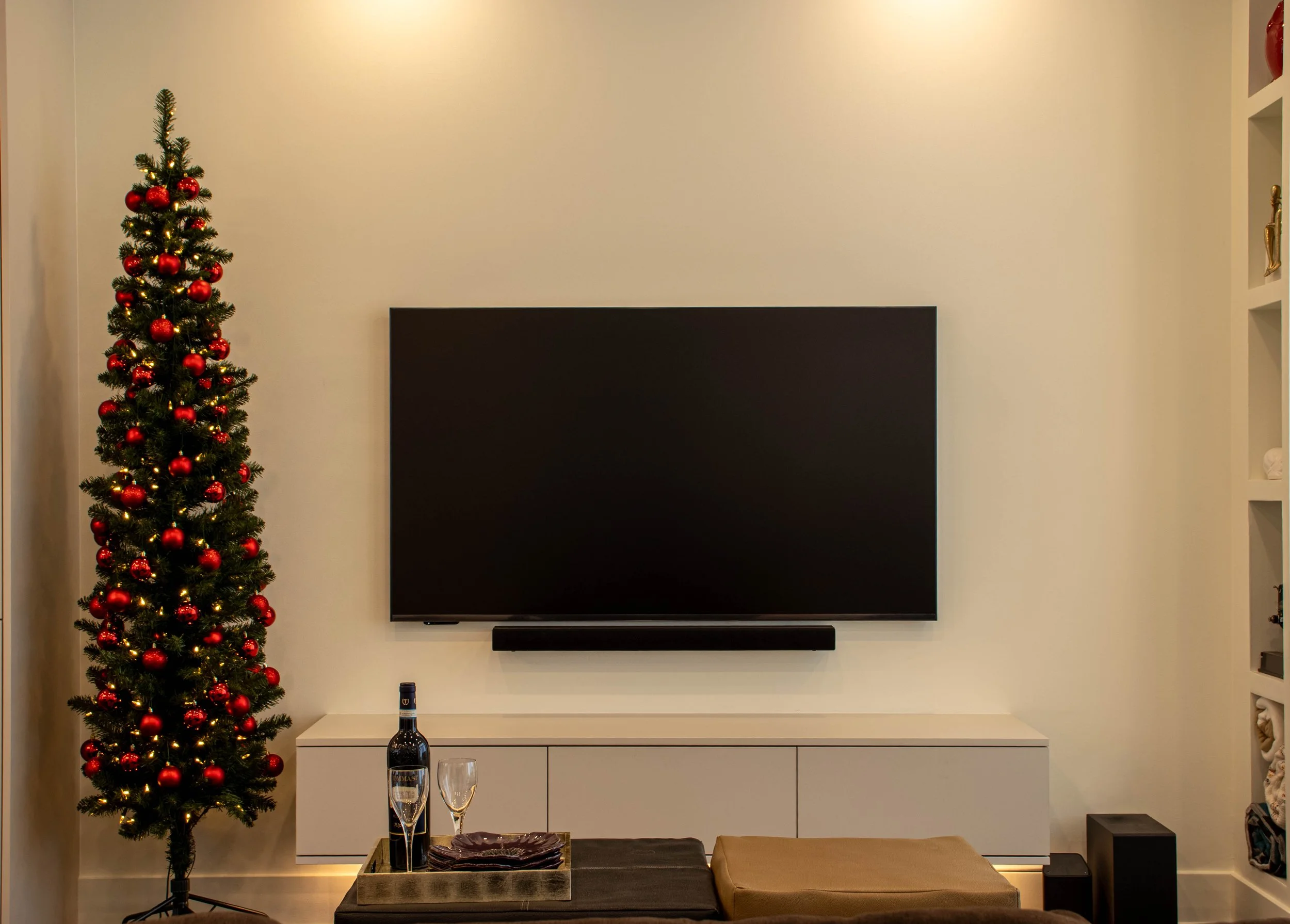 Modern luxury living room interior design in Toronto featuring custom media wall, integrated storage, and minimalist neutral palette
