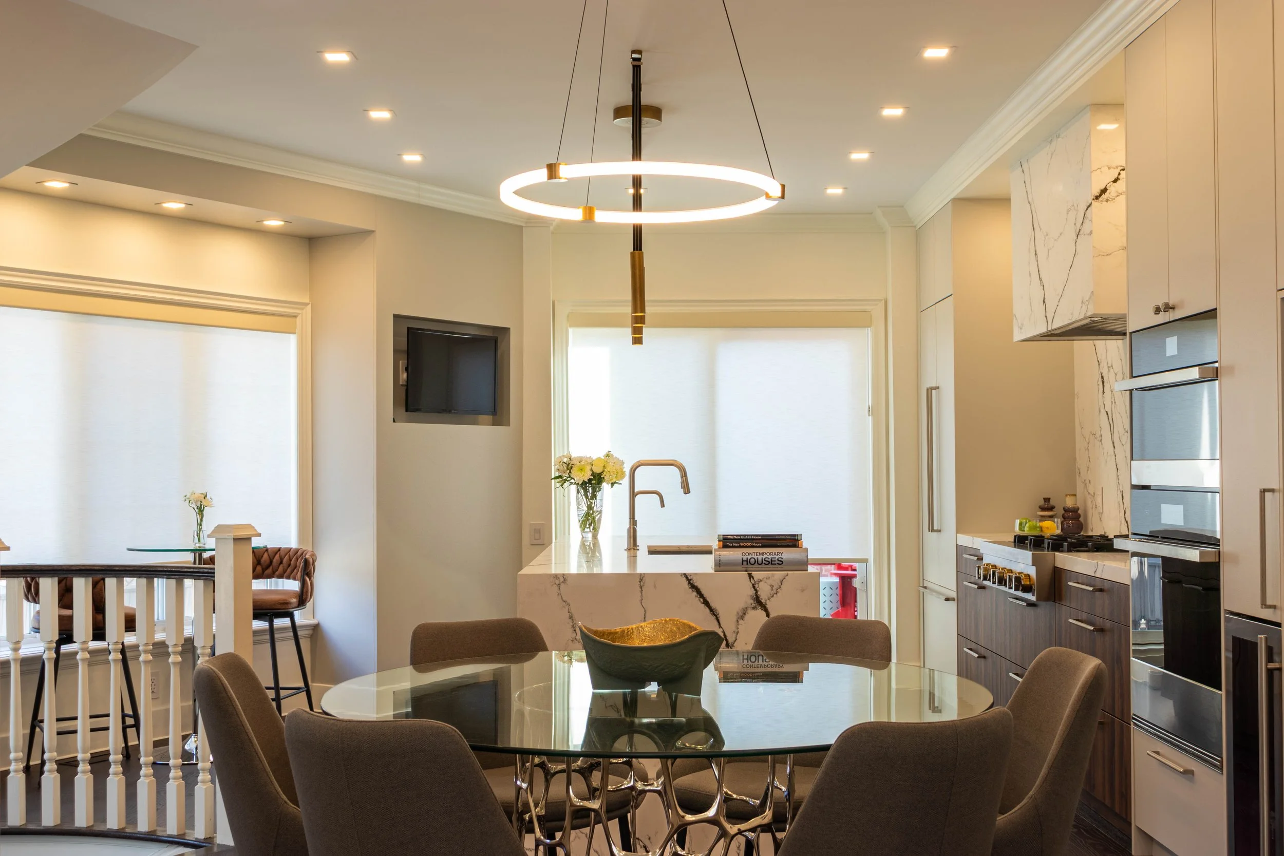 High-end residential kitchen with veined marble backsplash, custom millwork, and sculptural pendant lighting