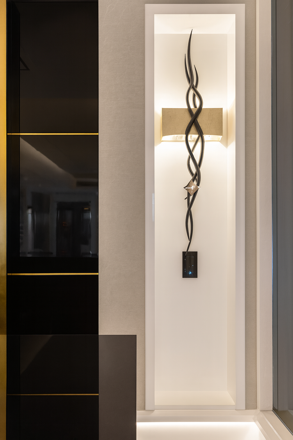 Modern wall niche featuring sculptural accent lighting and custom millwork details in a luxury residential interior.