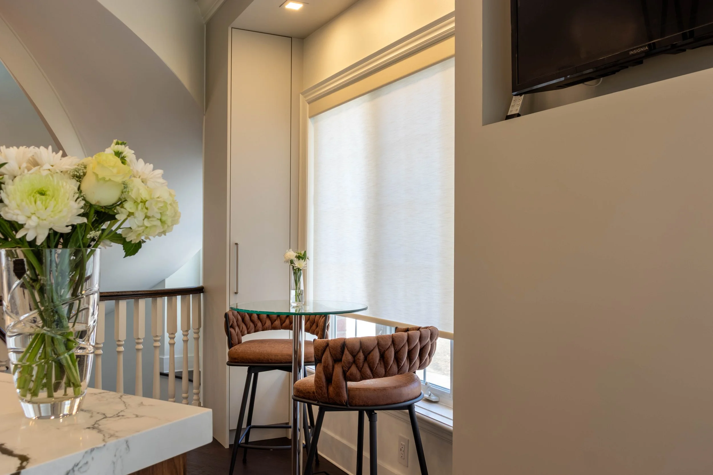 Luxury dining area with glass table, custom cabinetry, and contemporary lighting design