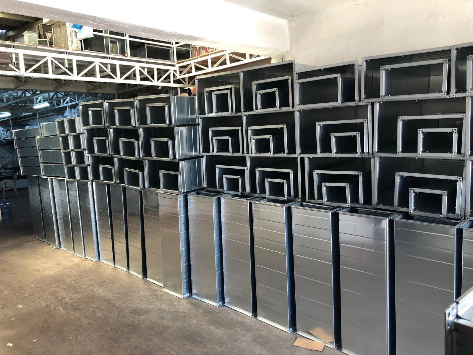 Stacked metal frames and panels in a workshop or storage area.