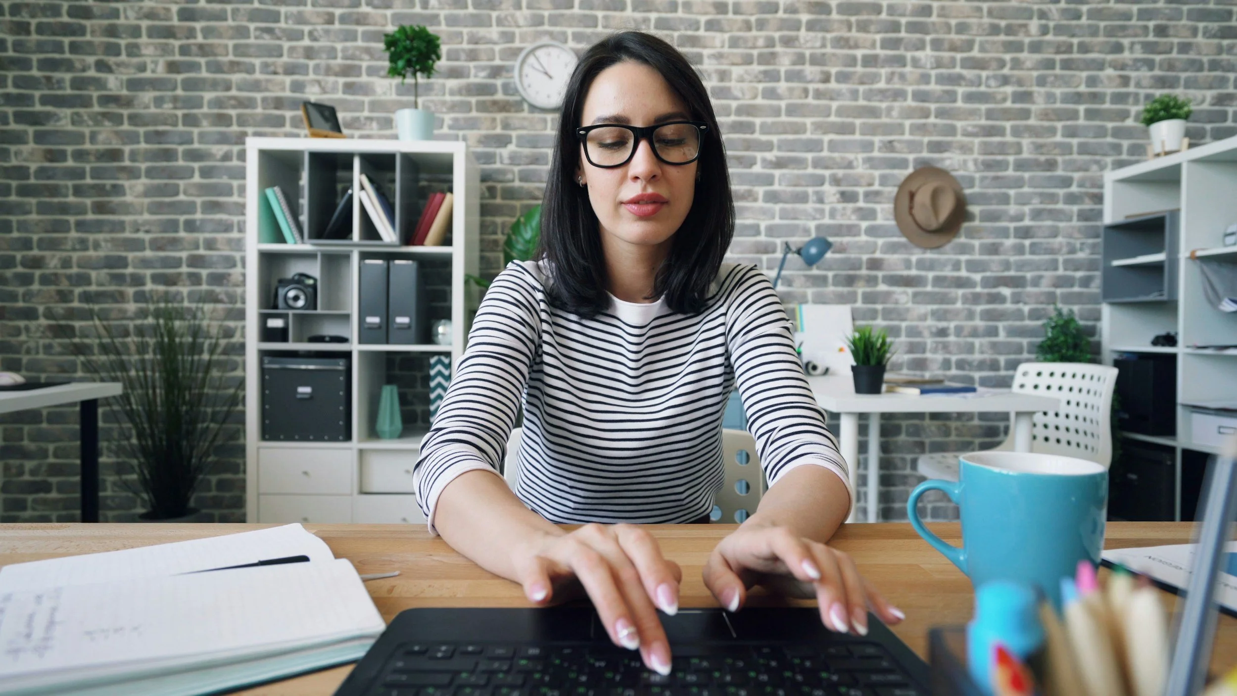 Virtual assistant working at a desk managing tasks for a small business owner through Simplify, Simplify VA services