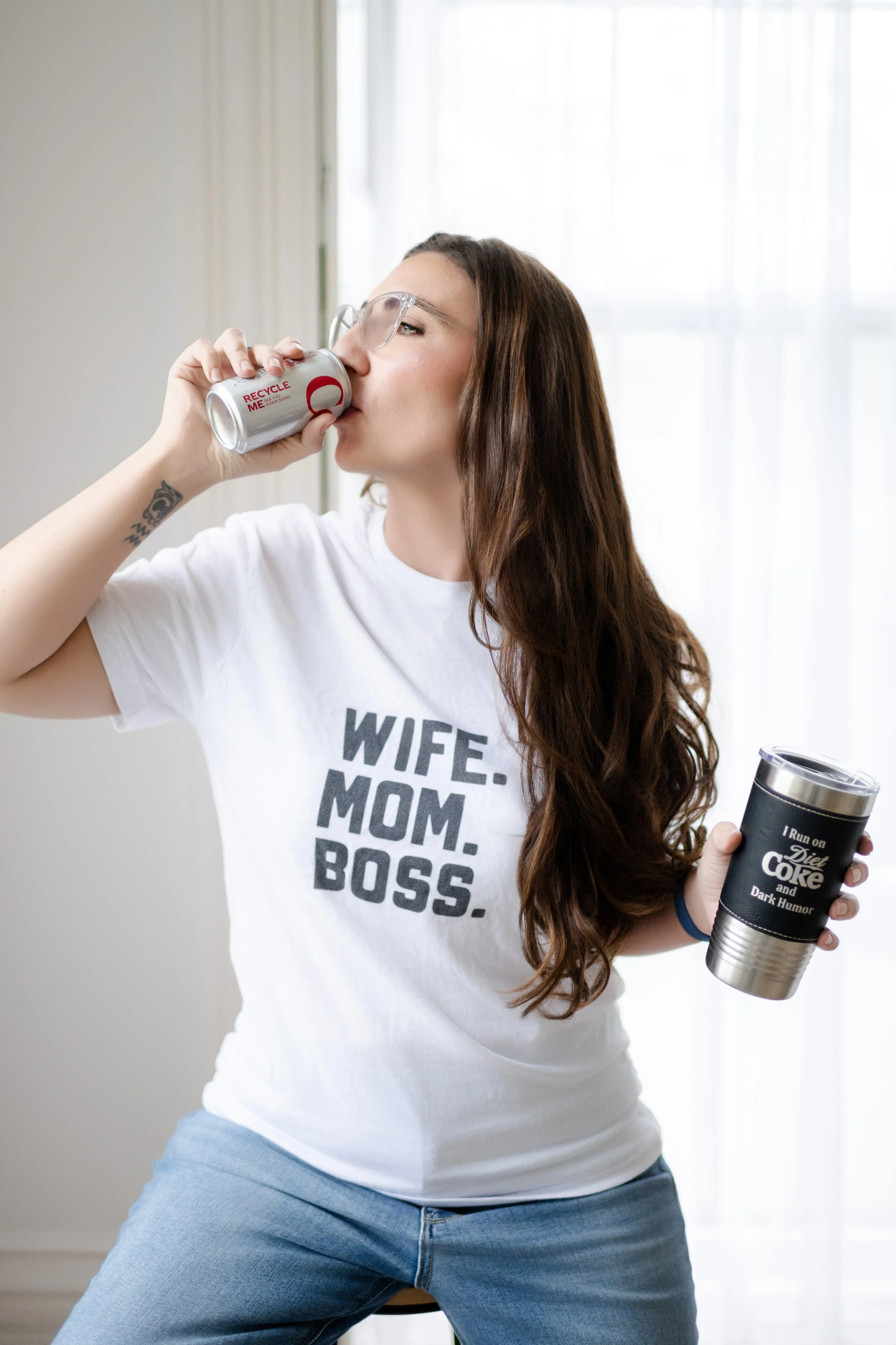 Liz August, business owner, wearing a ‘wife mom boss’ shirt and drinking a Diet Coke, representing her personal brand and entrepreneurial life.