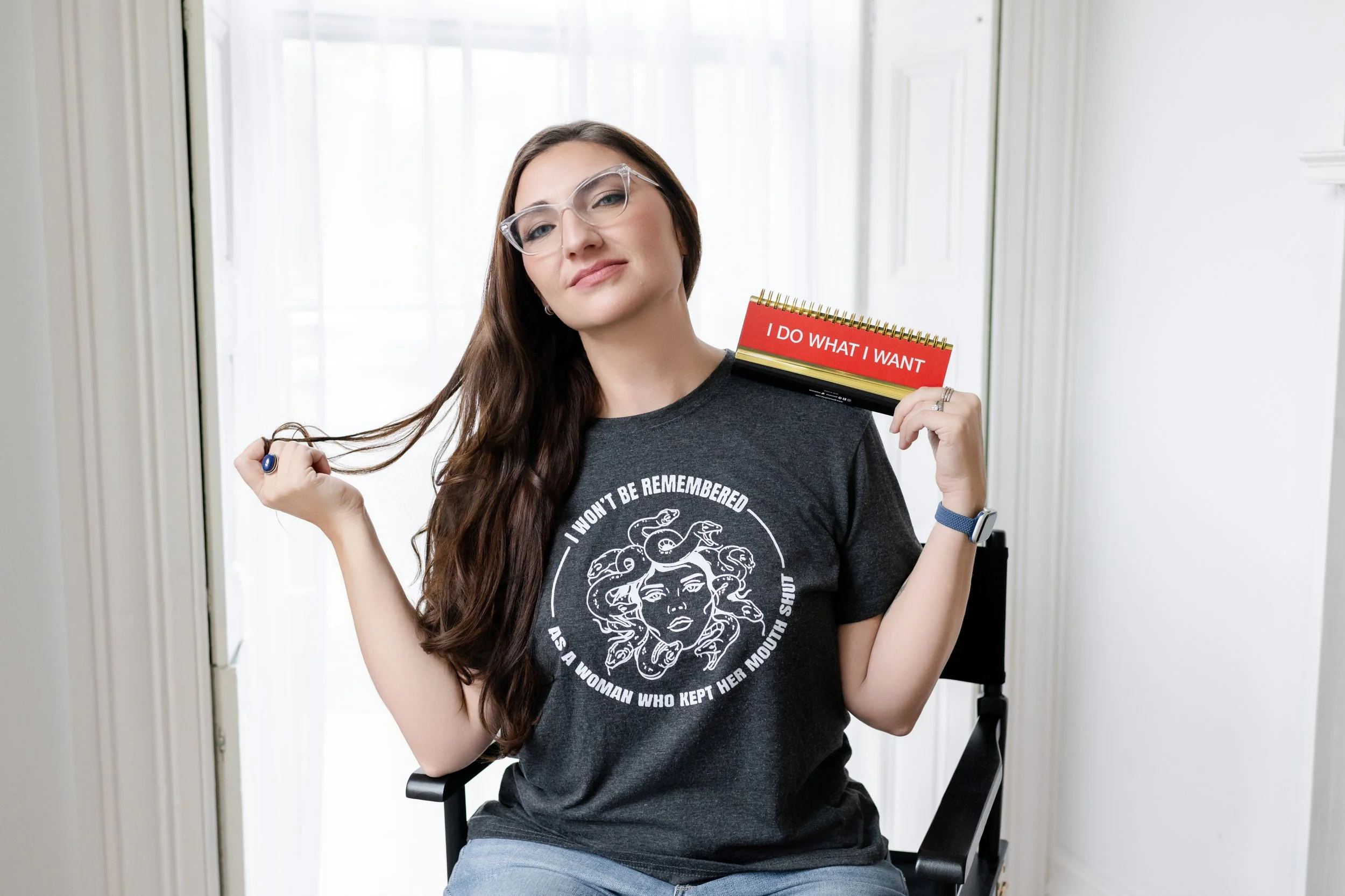 Liz August, business owner, smiling confidently while holding a notepad that says ‘I do what I want