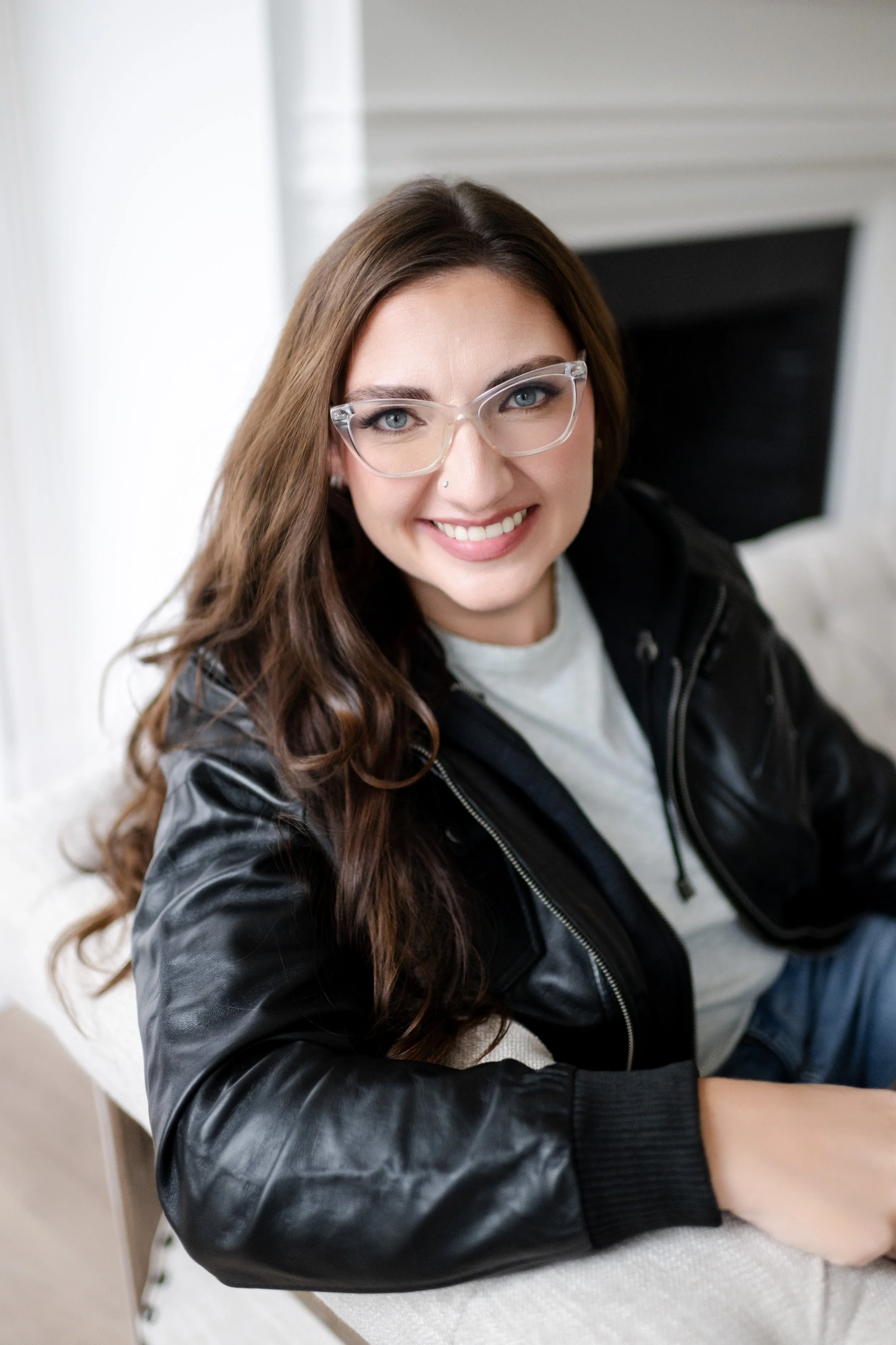 Liz August, founder of Simplify Simplify, smiling headshot in black leather jacket