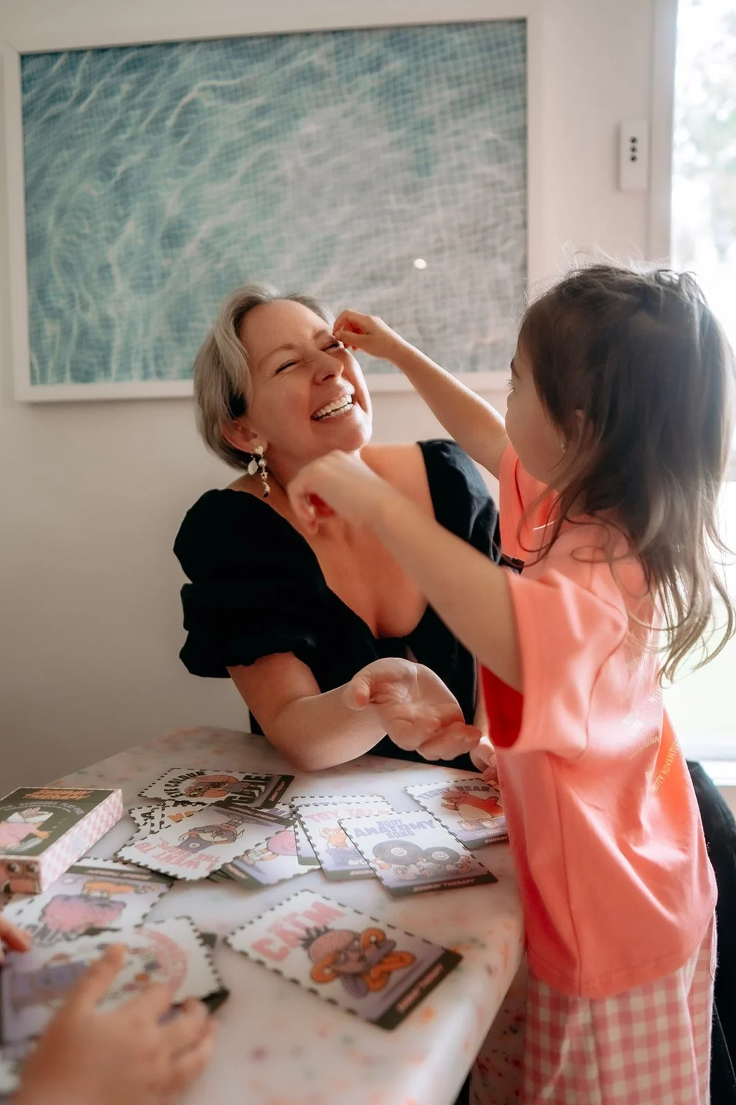 Founder Noni Croft playing with play therapy card deck emotional regulation tool with child