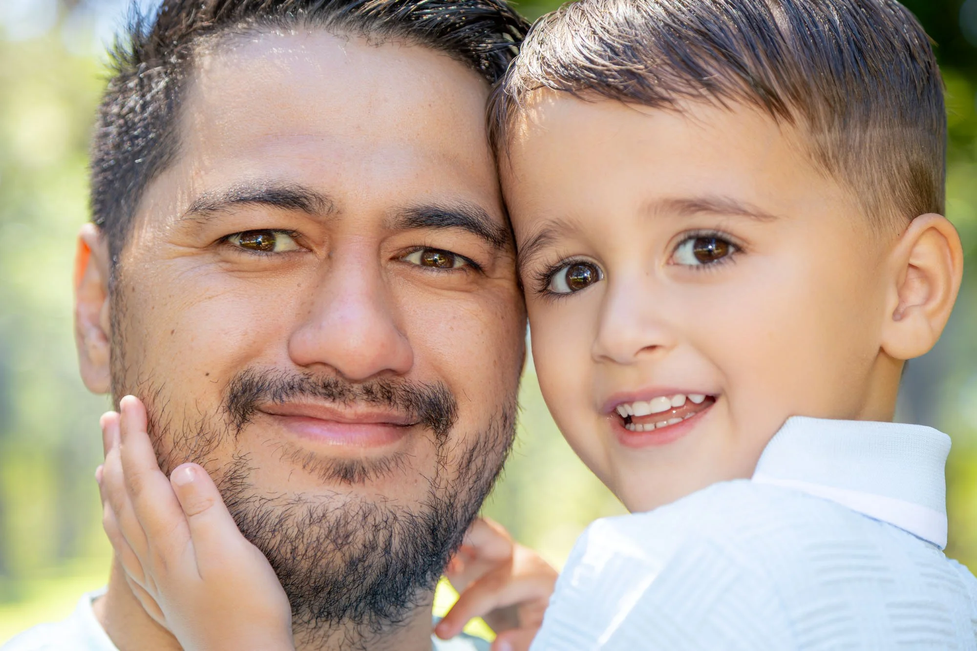 A father and young son sharing a close, affectionate moment during a natural outdoor family photoshoot by Southern Exposure Photography.