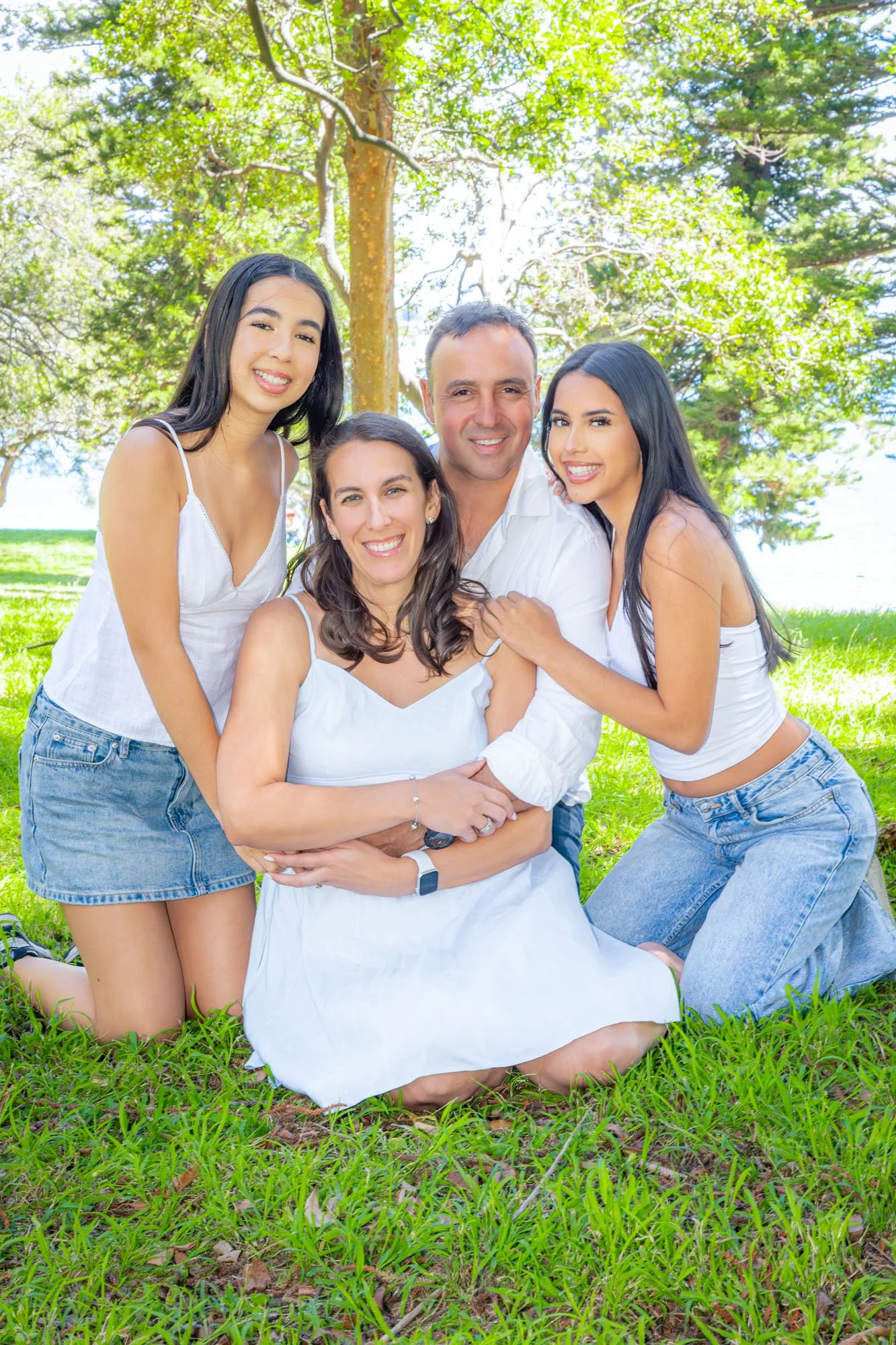 A family of four sitting together outdoors during a relaxed family photoshoot captured by Southern Exposure Photography.
