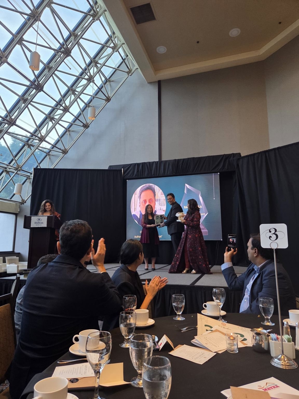Ravi on stage receiving award from Ampowering