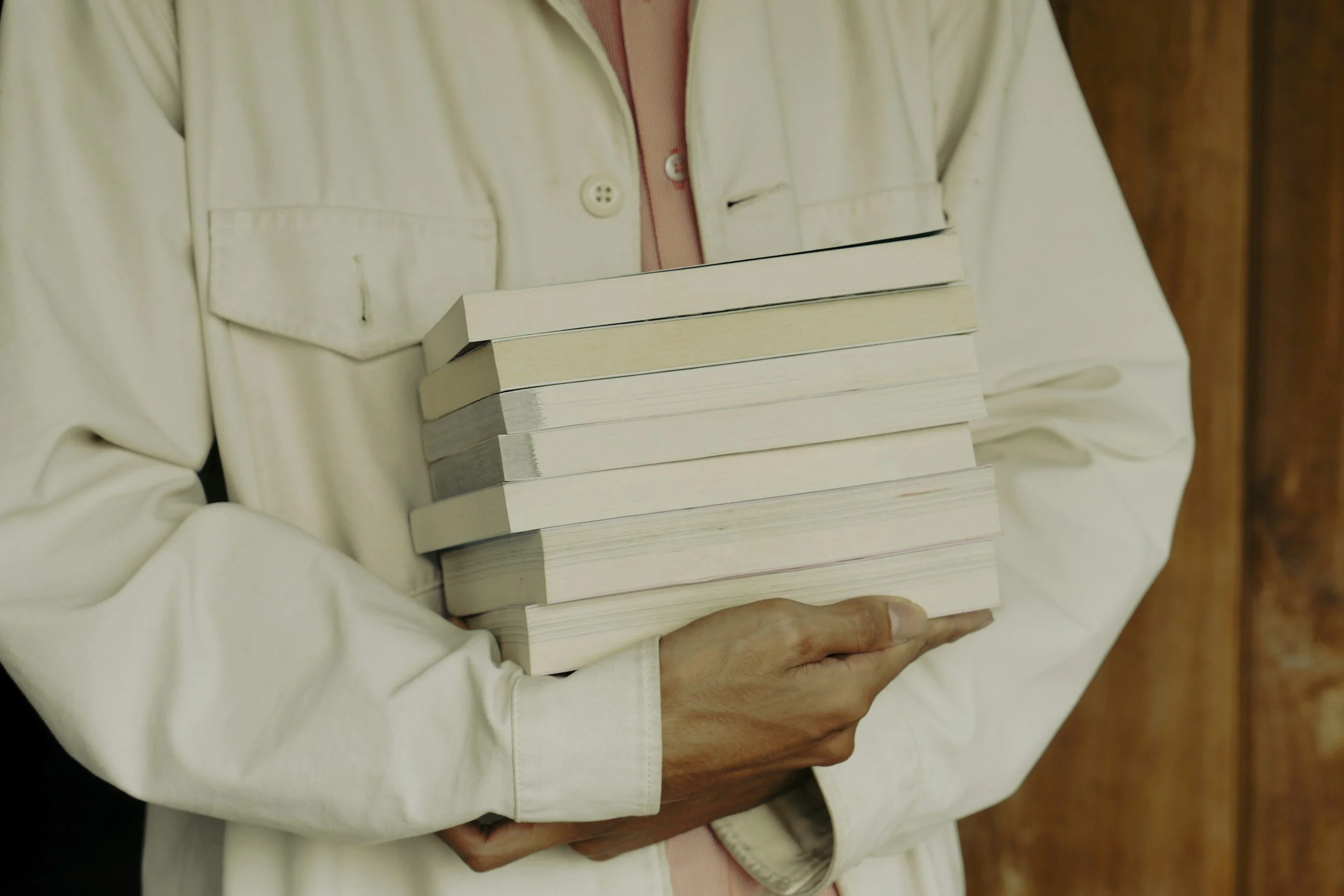 Person holding a stack of books