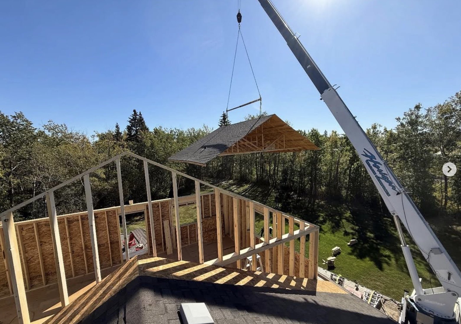 Major shop addition, mezzanine, roof being hoisted by a crane, Central Albeta