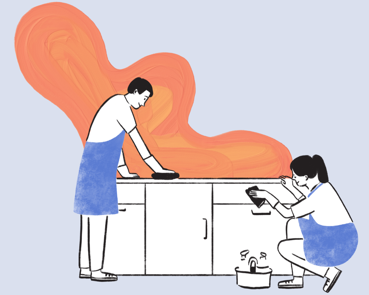 Two women cleaning a kitchen counter with orange clouds of steam in the background, one wiping the surface, the other taking a photo with a smartphone.