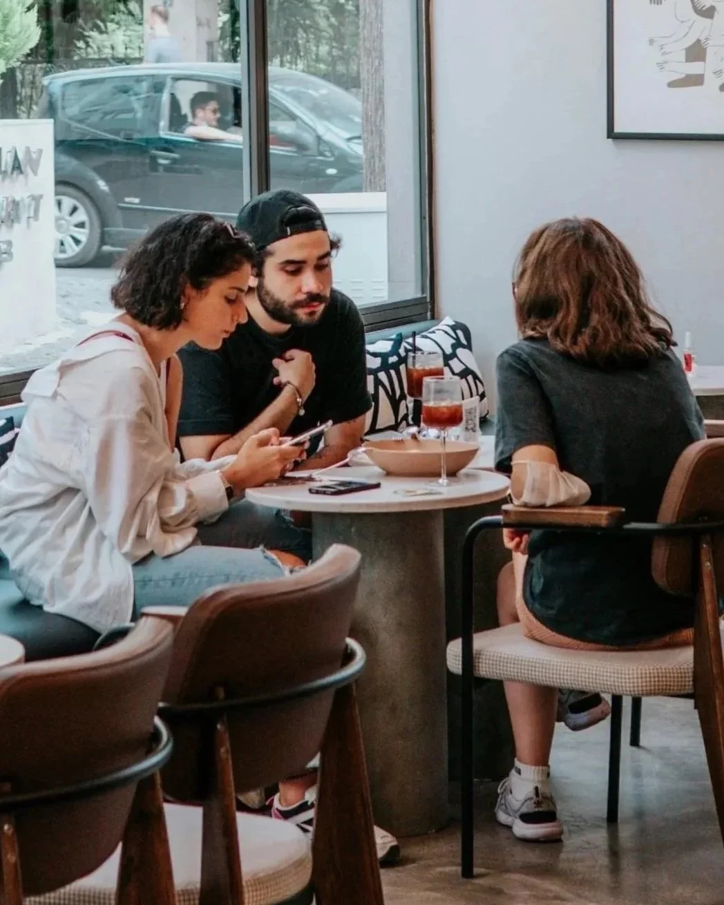 Three people engaged in conversation at a table, representing collaboration, communication, and healthy partnerships.