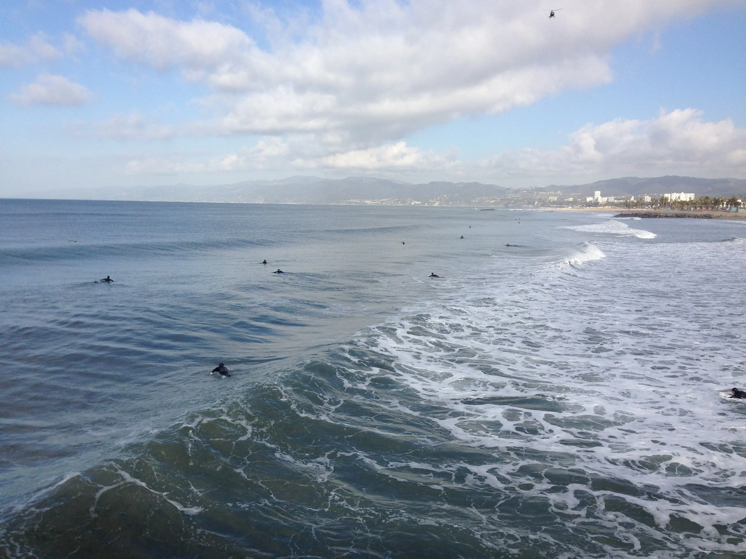 Surfers waiting in the ocean as waves approach the shore