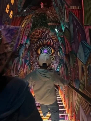 Child climbing stairs toward surreal doorway representing moving through anxiety in therapy with Rosalie Maduro LMFT in Los Angeles, San Francisco, and Park City.