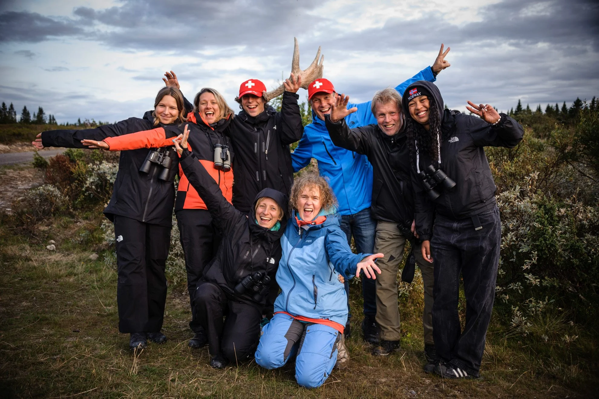 Group of seven people at our guided tour, outdoors on a cloudy day, smiling and posing for a photo.