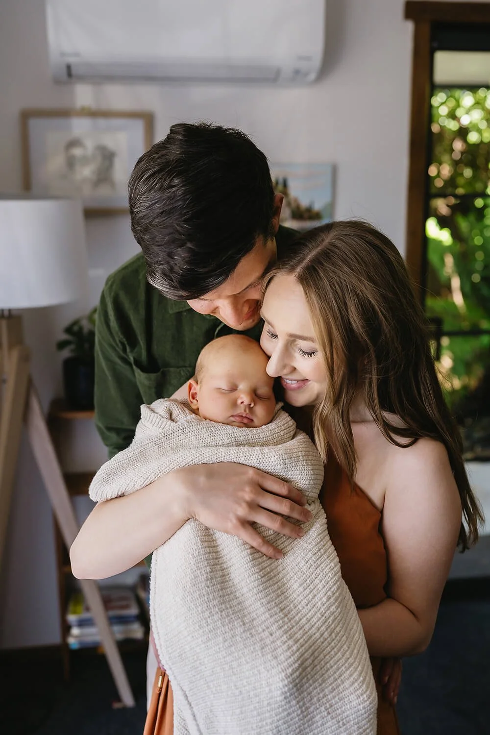 Couple holding newborn baby a Hobart in home newborn session