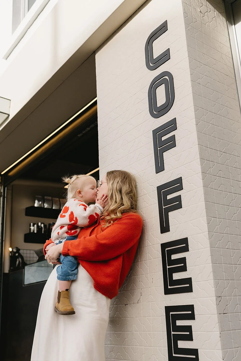 Mum enjoying a babycino with her daughter during a lifestyle Motherhood Photography session in Hobart.
