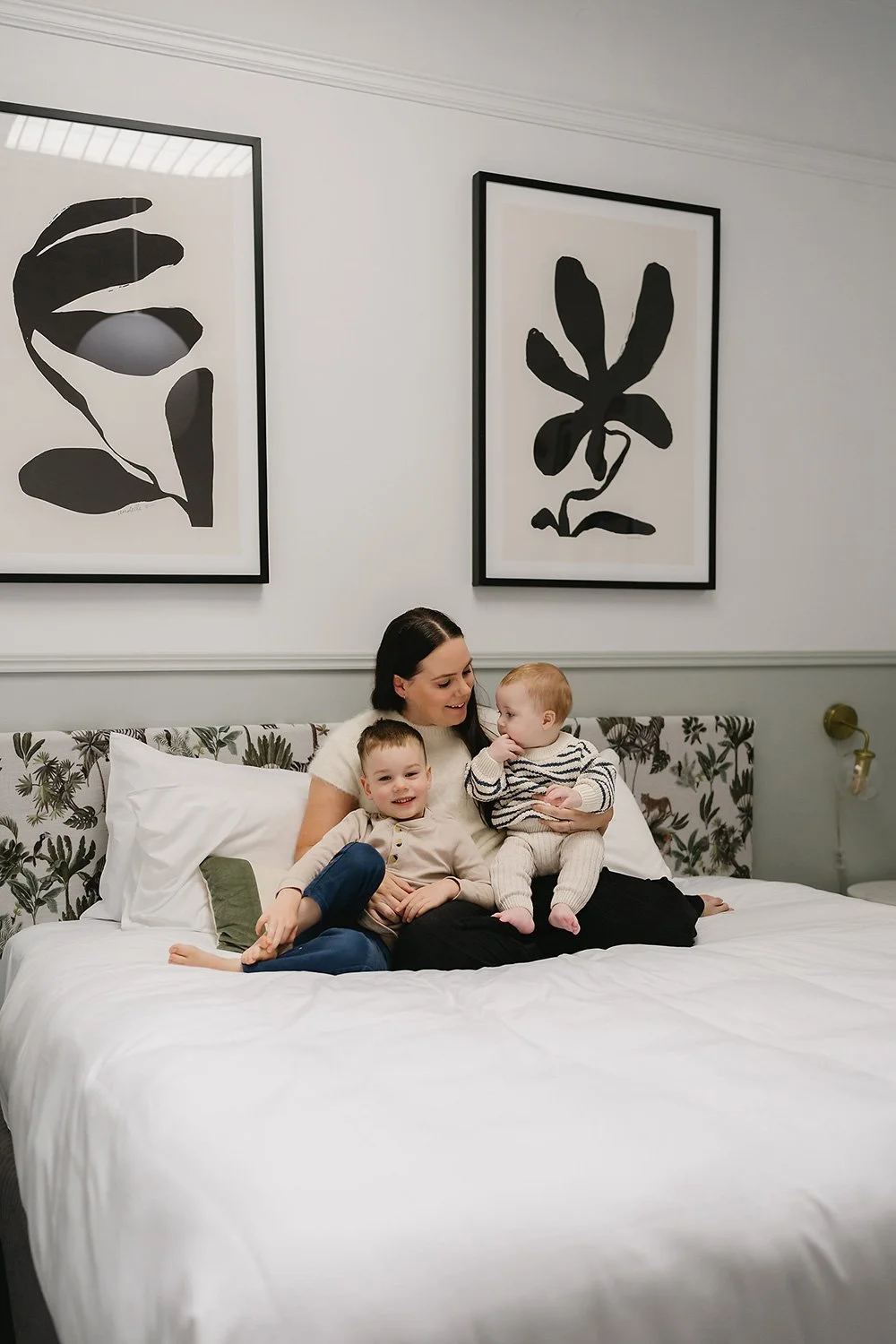 Mother cuddling with her two children on a bed