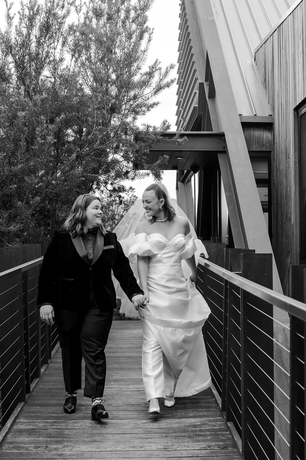 Same sex couple walking holding hands on wedding day being photographed by Hobart wedding photographer