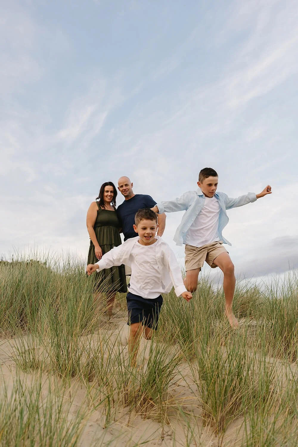 Family running at the beach having their photo taken by a Hobart photographer