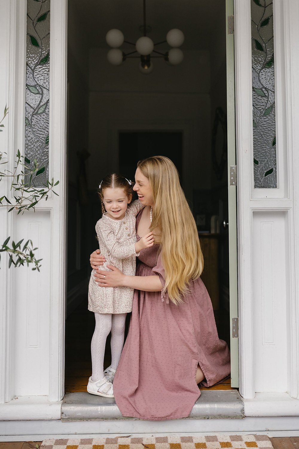 Mother cuddling her daughter in a doorway