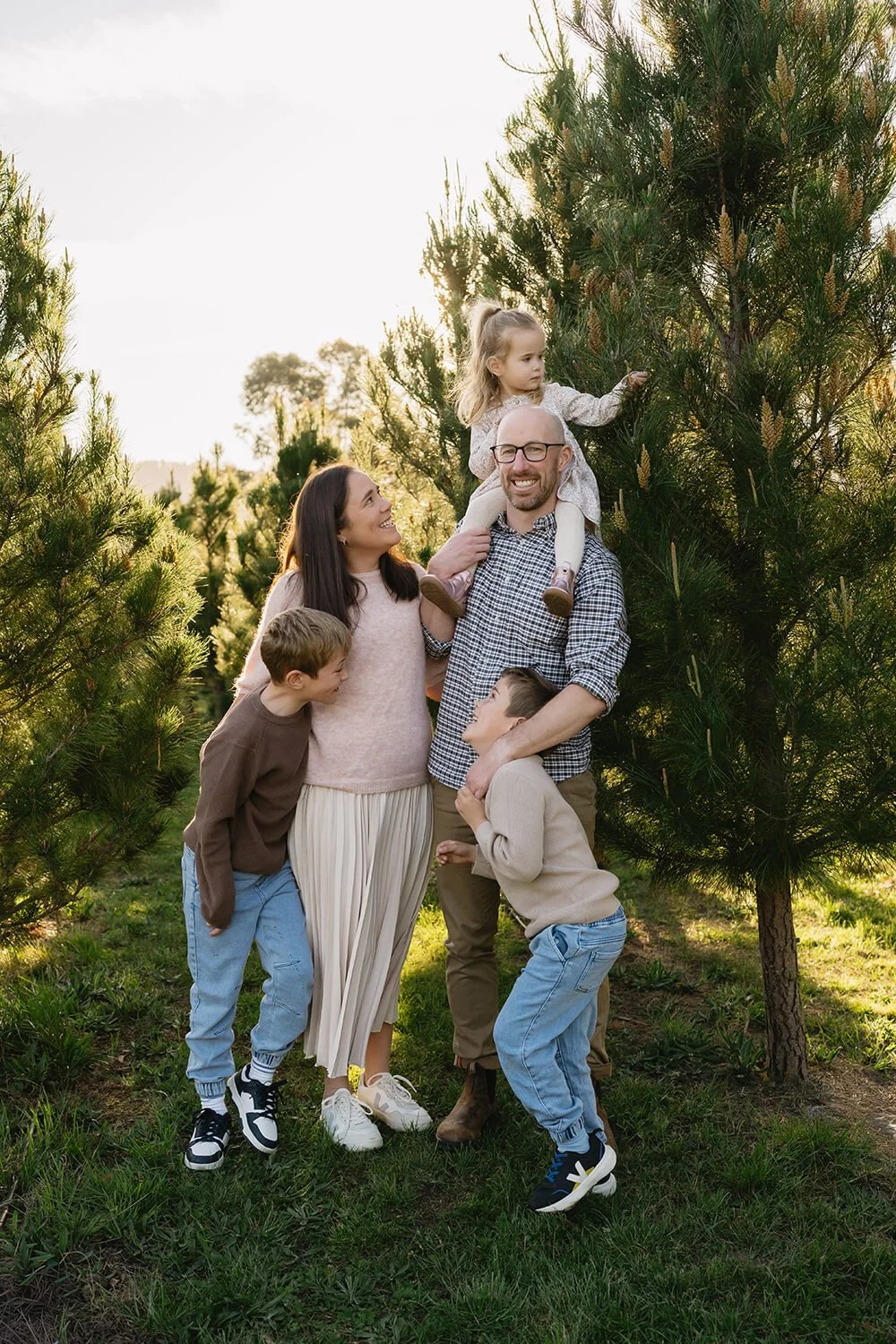 Family posing in field of Christmas trees during Hobart Christmas Mini Sessions