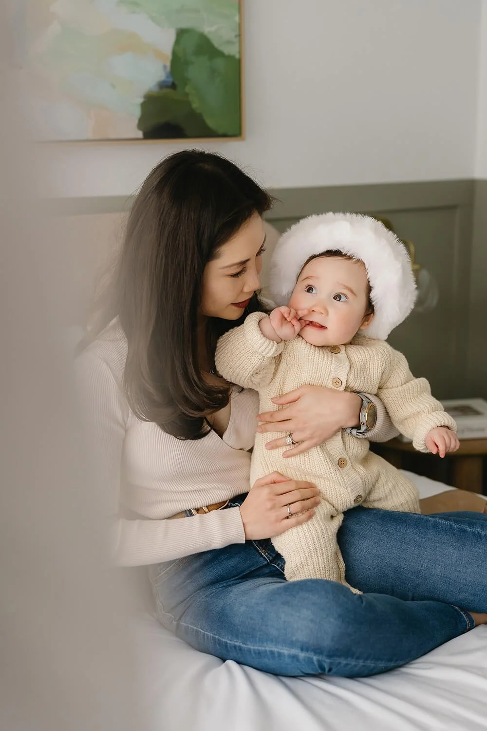 Mum and baby on bed wearing Christmas hat at Christmas mini session Hobart
