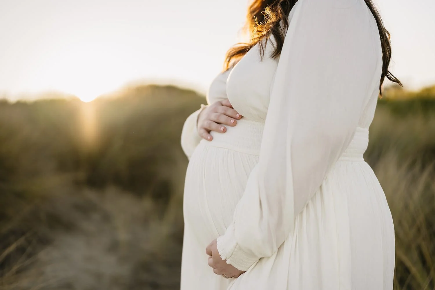 Close up photo of pregnant belly being photographed by maternity photographer in Hobart