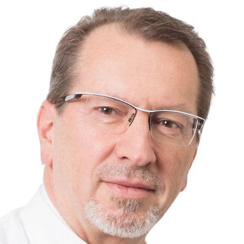 Close-up of a middle-aged man with glasses, gray hair, and a trimmed beard, wearing a white shirt, against a plain white background.