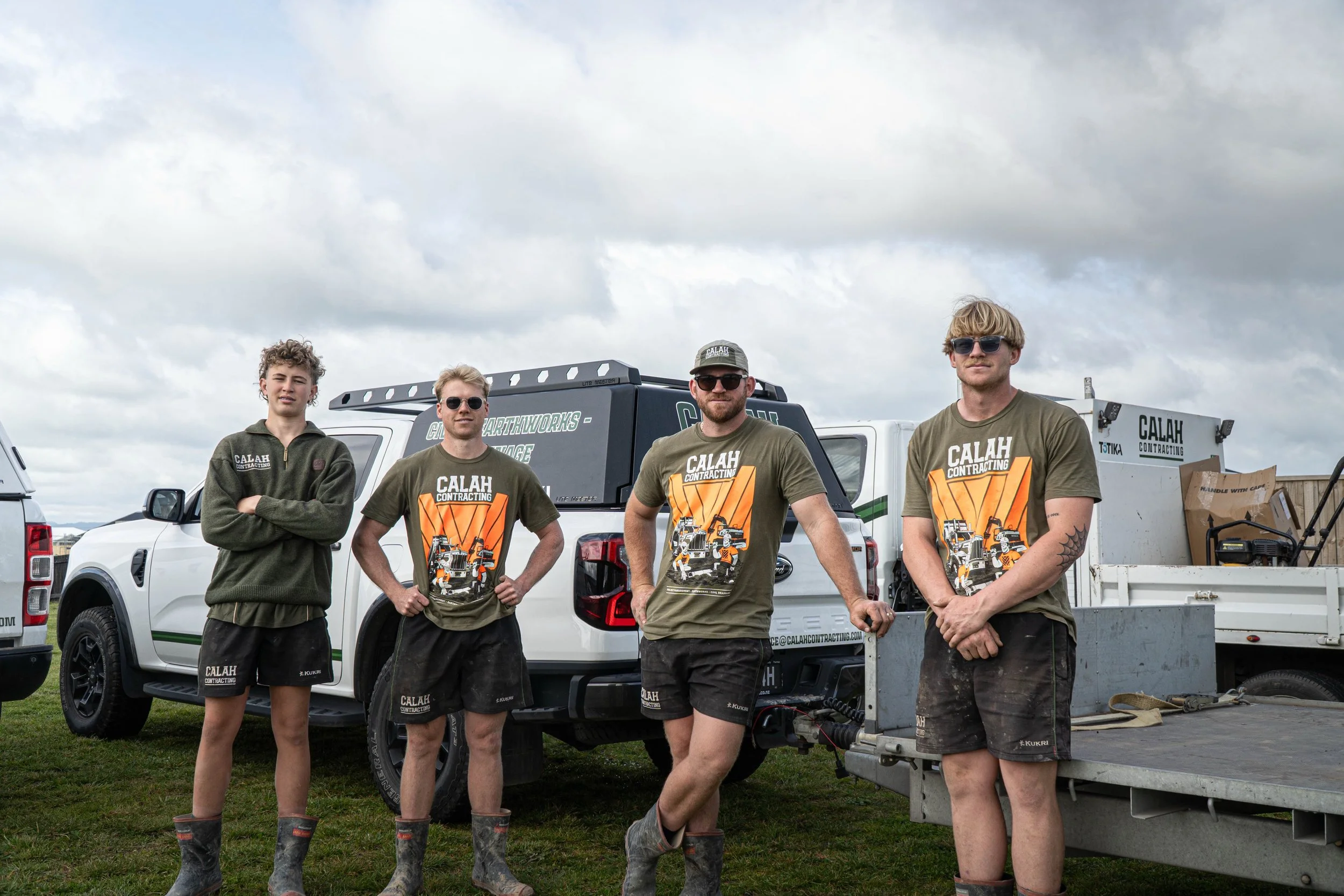 Landscaper in safety gear on a jobsite next to landscaping and earthworks equipment.